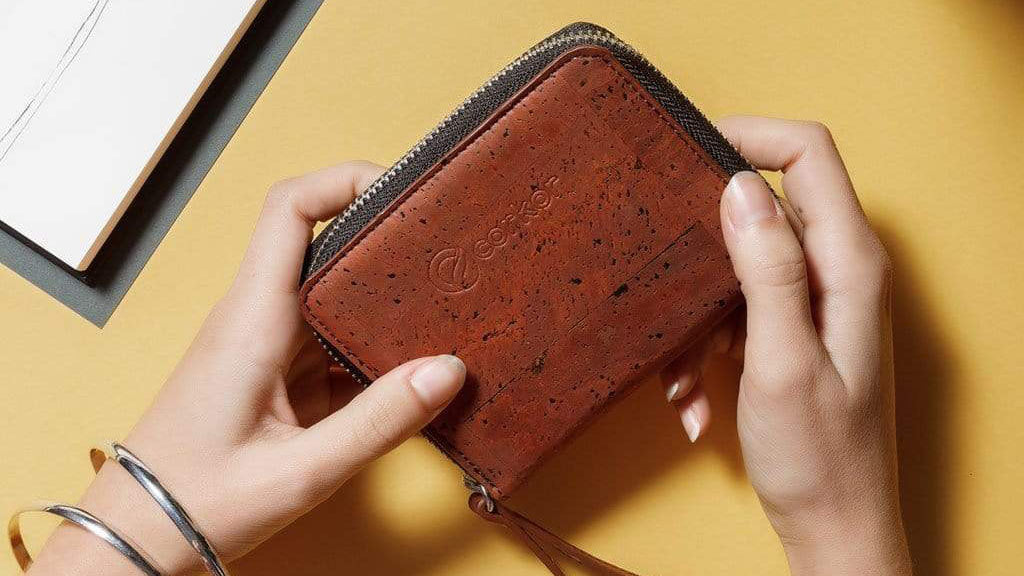 Hands holding a Corkor vegan leather cork wallet in red