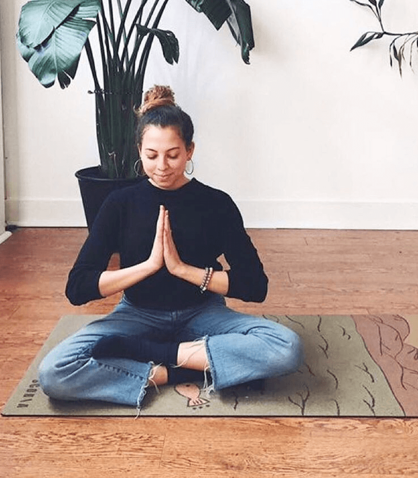 Girl meditating on a Scoria World cork yoga mat